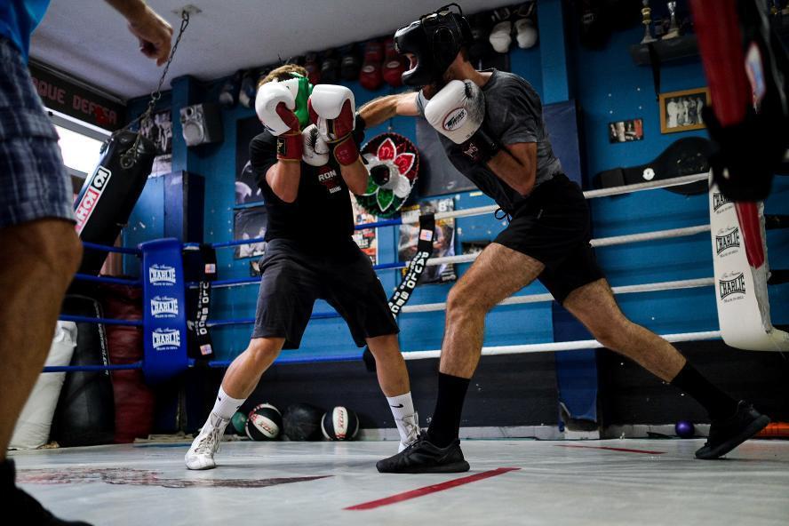Fotografia ilustrativa: dois atletas a treinar boxe num ringue.