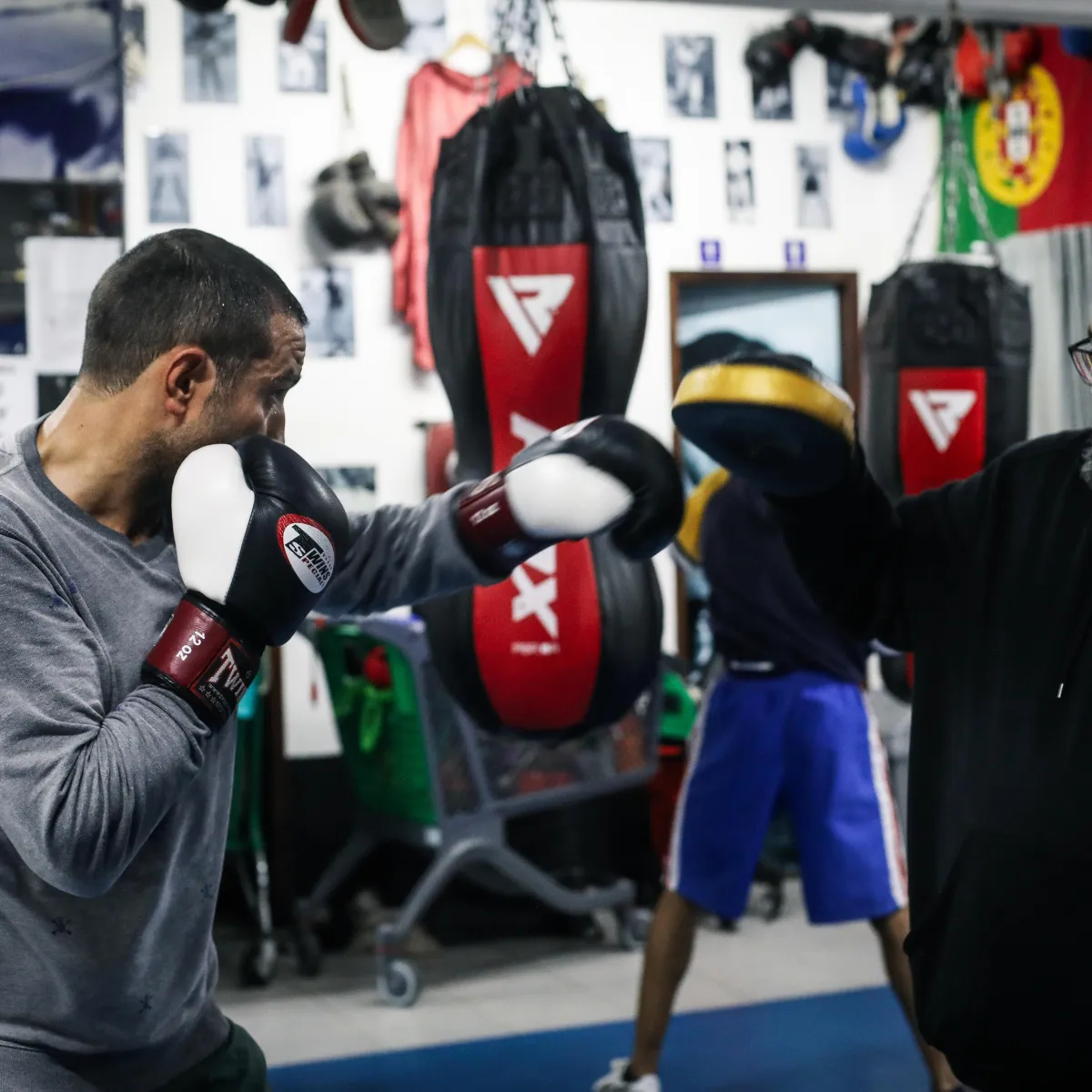Fotografia ilustrativa: treino de boxe com luvas e manoplas.